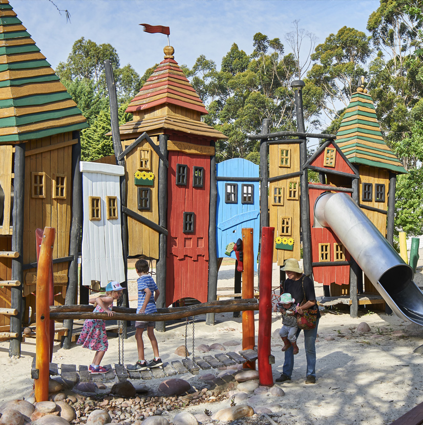 children and a parent playing in the playground